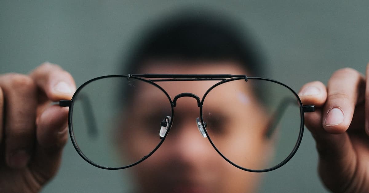 Person holding large black glasses