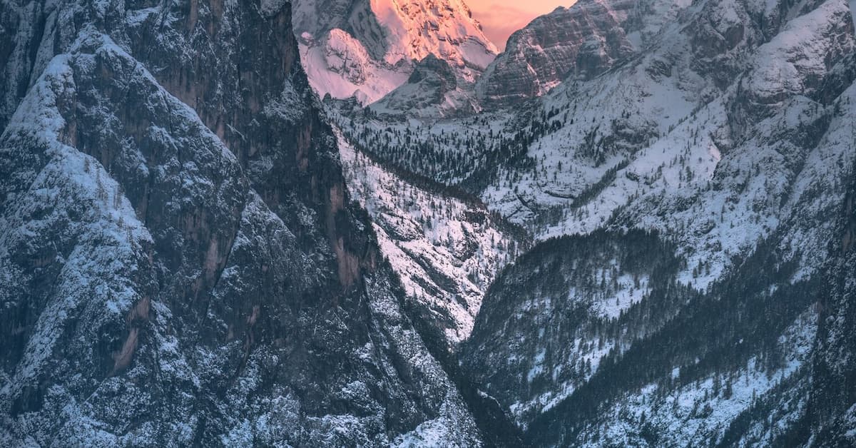 Snowy mountains at sunset glow
