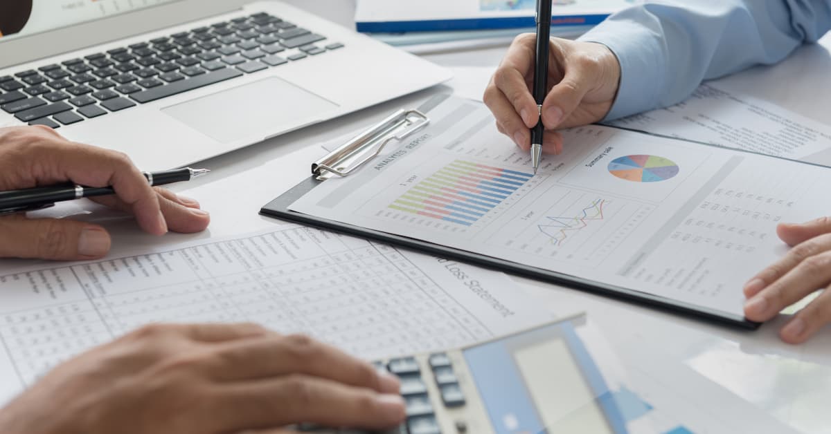 5 Financial Mistakes Small Businesses Make (and How to Fix Them) (Banner Photo) Hands analyzing financial documents and charts.