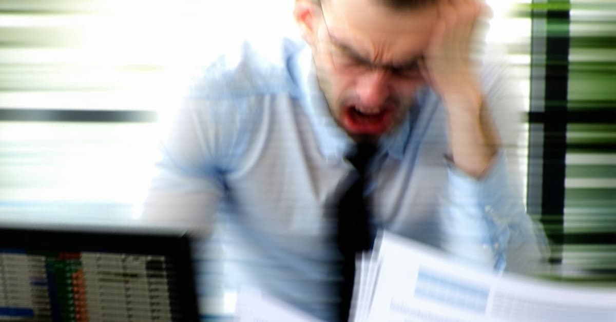 Frustrated accountant surrounded by paperwork.