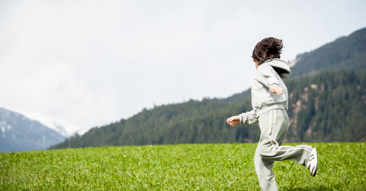 Child on beautiful mountain field Child running in green mountain field