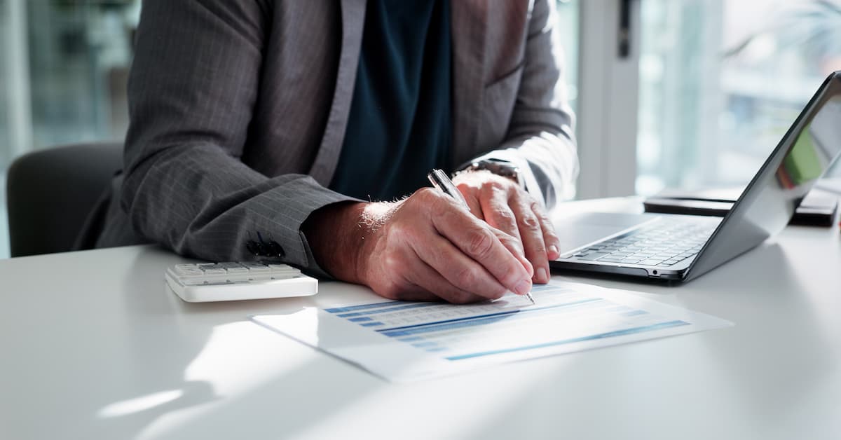 Person analyzing financial documents at desk