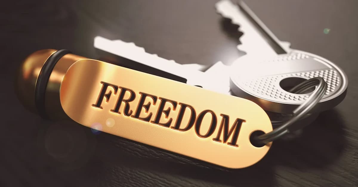 Keys to Freedom – Concept on Golden Keychain over Black Wooden Background. Closeup View, Selective Focus, 3D Render. Toned Image Golden keychain with 'FREEDOM' tag