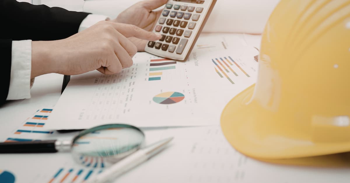 Calculator, charts, construction helmet, analysis.