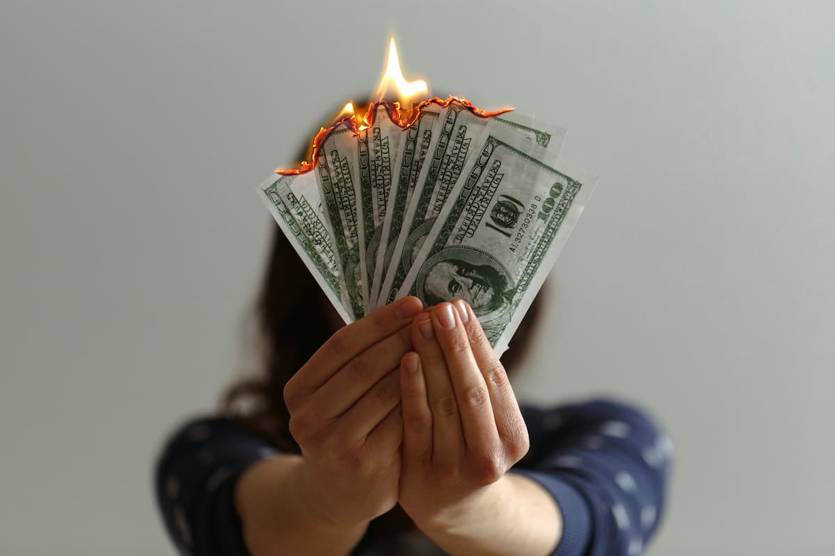 Burning money held by a person